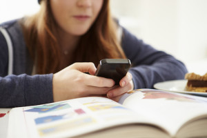 teen texting while studying