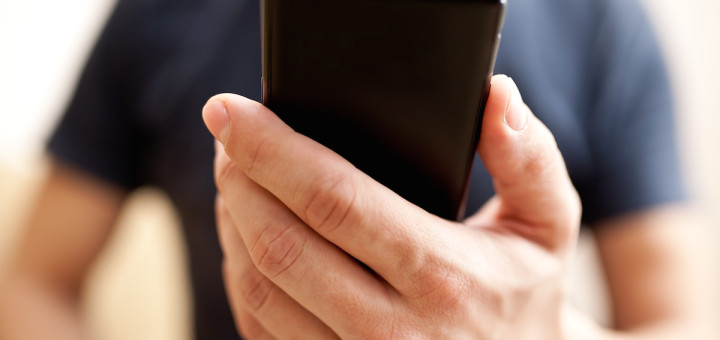 image of man holding mobile phone and texting